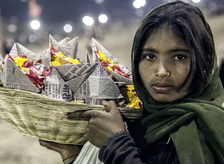 Khumb Mela, rapariga a vender flores para colocar no rio