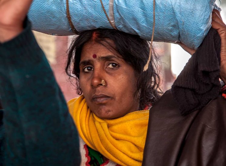 Khumb Mela, mulher a carregar grande saco à cabeça