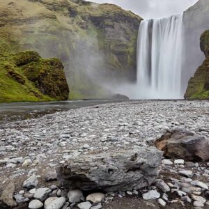 Islândia, rochas e vegetação verde nas imediações da cascata Skógafoss