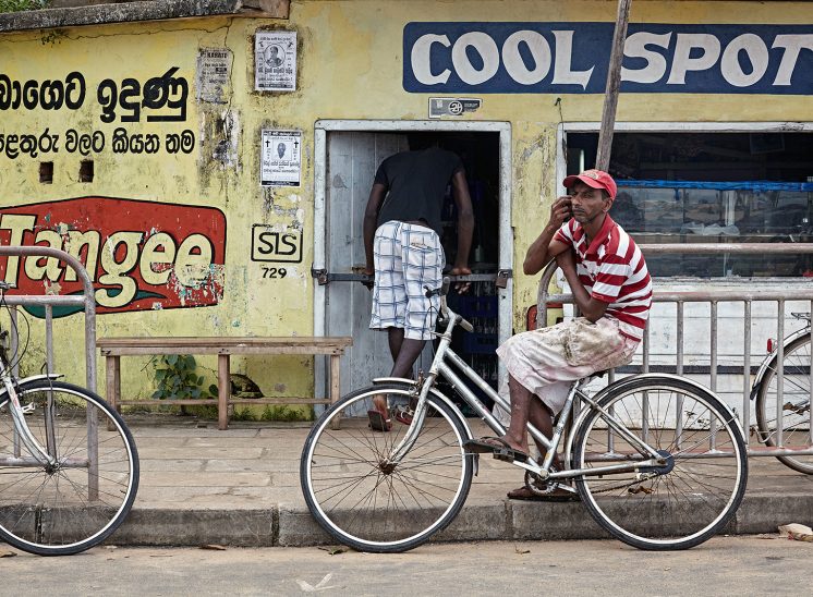 Sri Lanka, homem numa bicicleta junto a uma loja