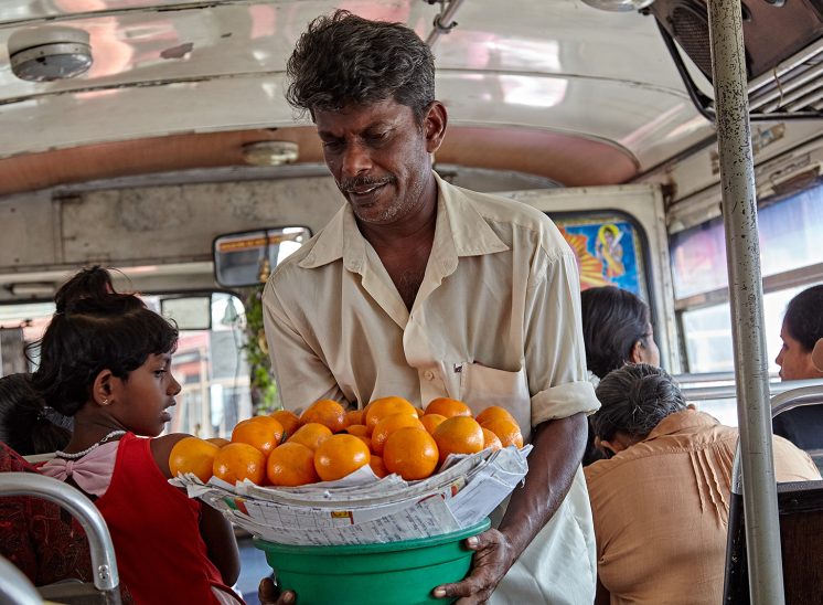 Sri Lanka, vendedor com cesta de laranças dentro de um autocarro