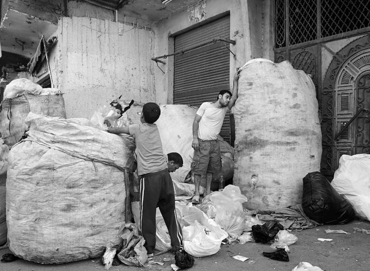 Mokattam Zabbaleen, rapazes a encher grandes sacos com plástico