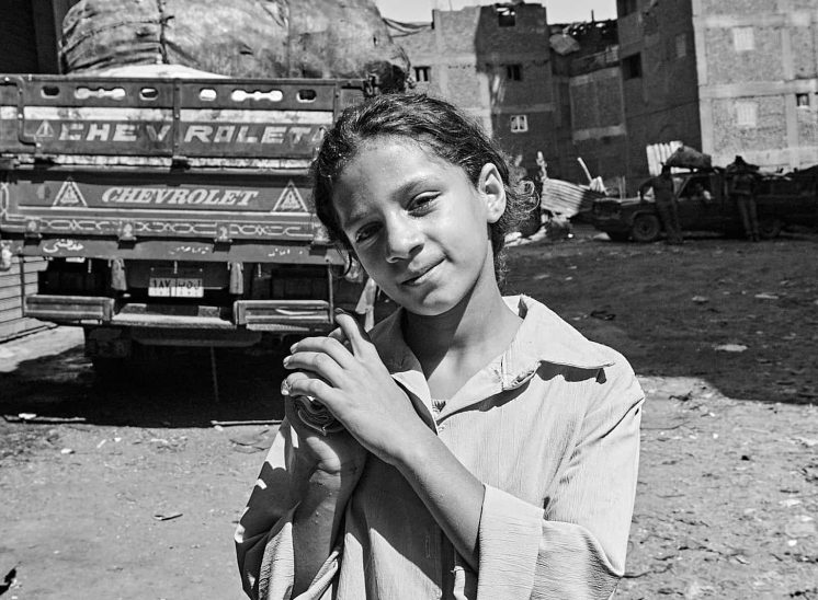 Mokattam Zabbaleen, menina à frente de um caminhão cheio de lixo