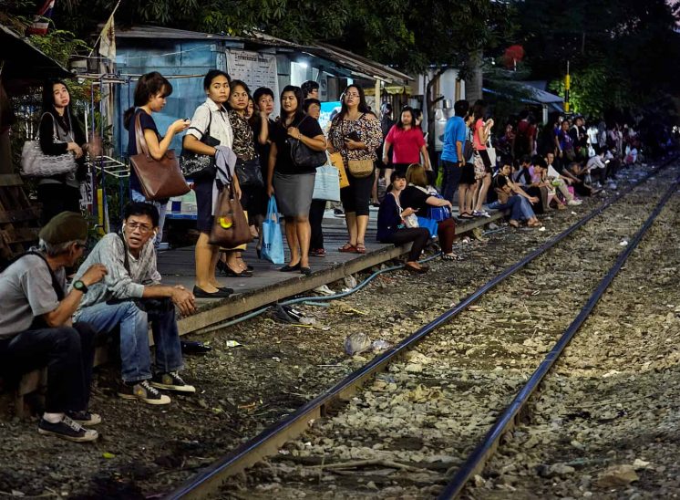 Tailândia, pessoas junto à linha de comboio perto de Phaya Thai, em Banguecoque