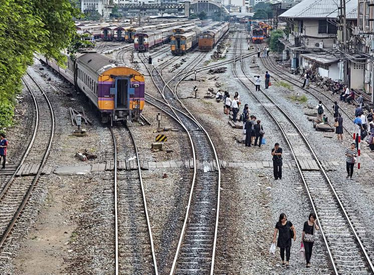 Tailândia, pessoas e comboios nas linhas ferroviárias sob a estrada Bamrung Muang, em Banguecoque