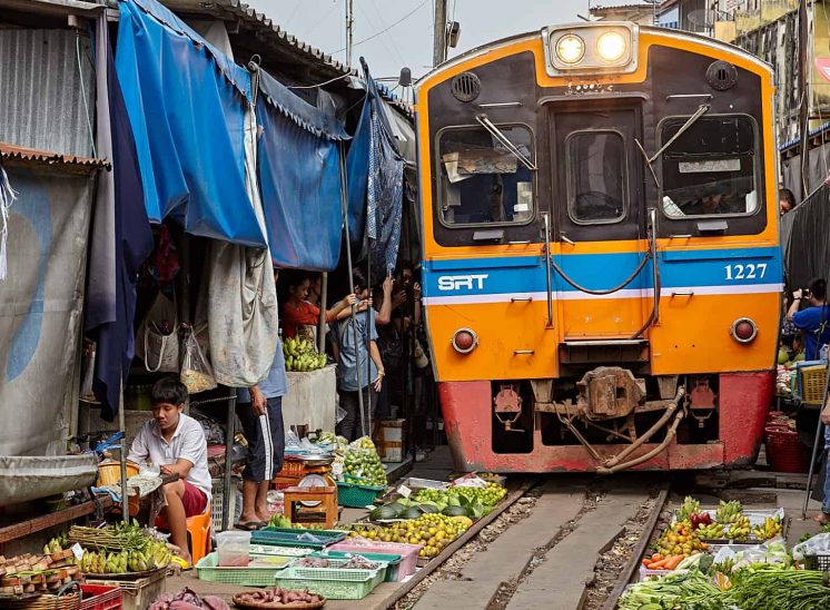 Tailândia, comboio amarelo a atravessar o mercado Samut Songkhram