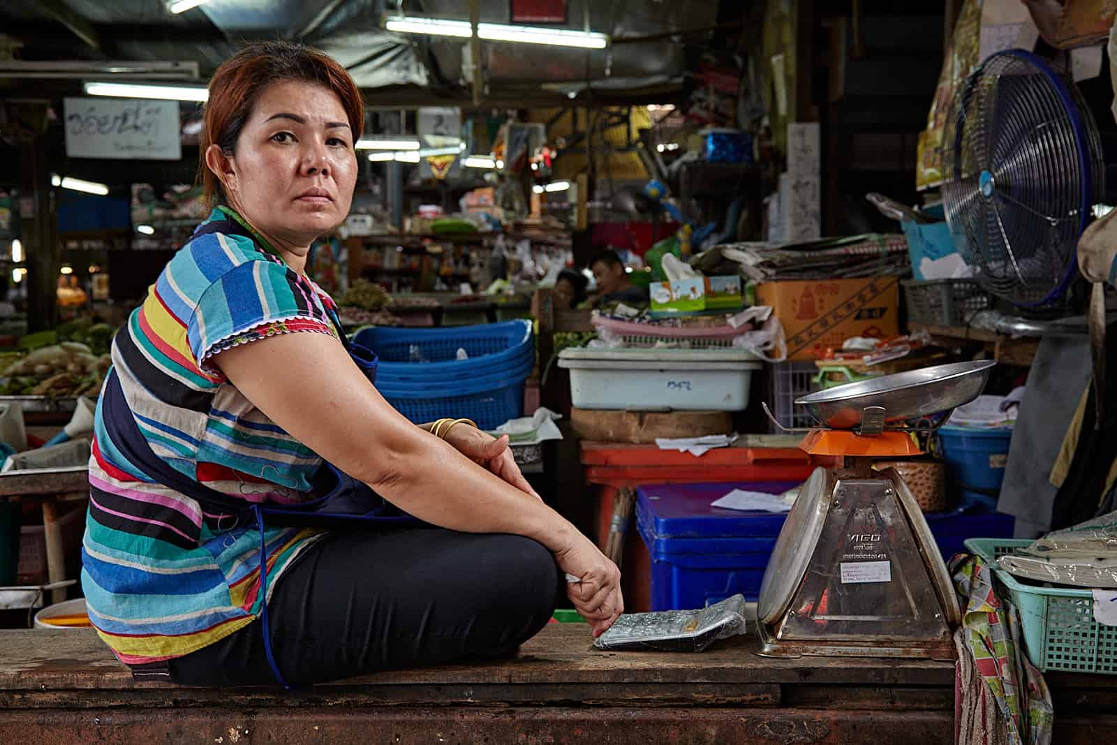 Tailândia, mulher e grande balança no mercado de Samut Songkhram