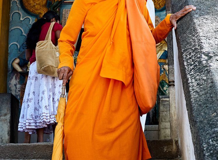 Sri Lanka, mulher monge a descer escadas de um templo em Kandy